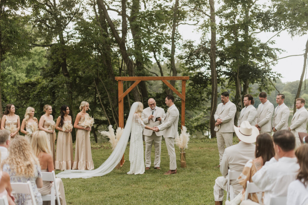 elegant country bride with a pampas and wood ceremony arch at an Annapolis, Maryland family farm wedding