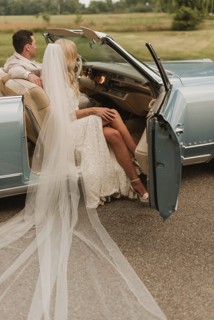 elegant country bride with a blue vintage car at an Annapolis, Maryland family farm wedding